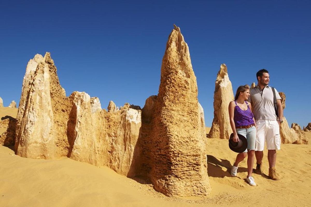a man and a woman standing in front of large rock formations