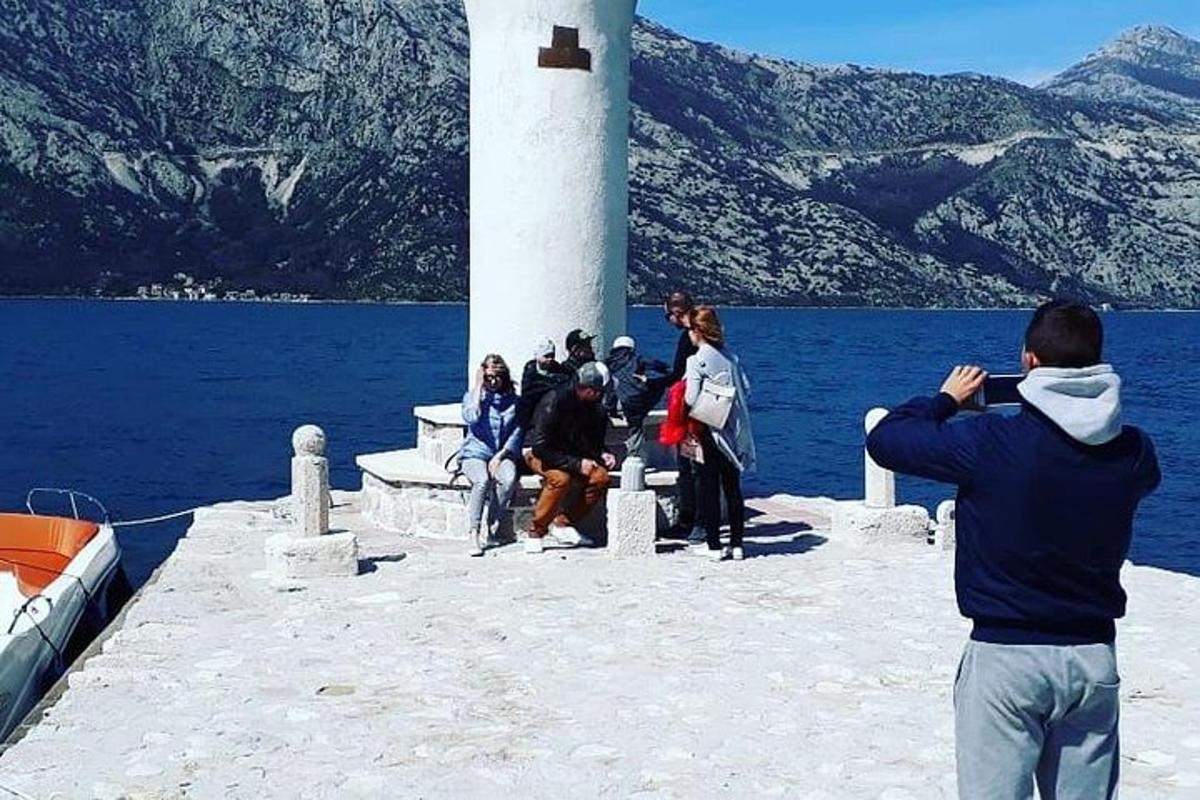 un uomo che scatta foto alle persone vicino a un faro