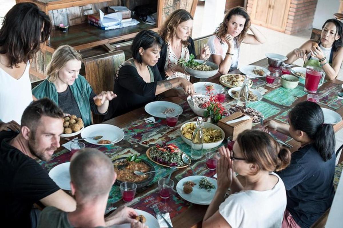 eine Gruppe von Menschen sitzt um einen Tisch herum und isst