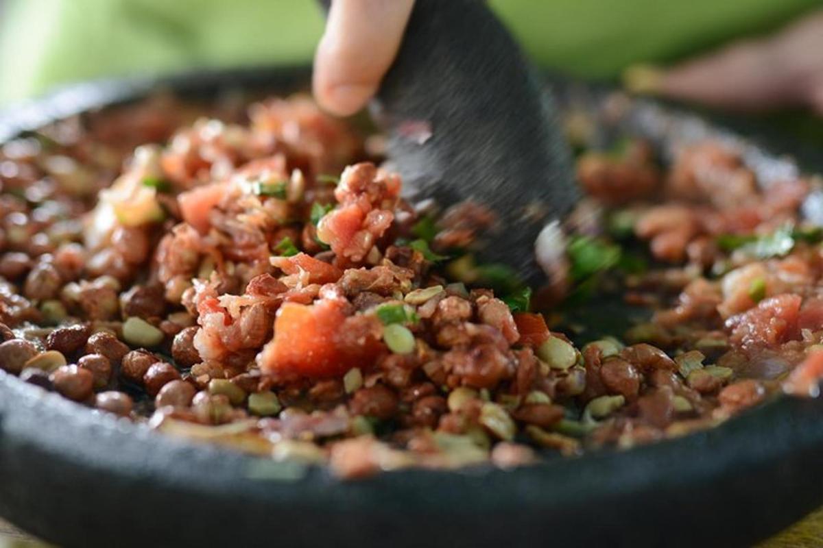 egy személy, aki kanalat tart egy tál ételben