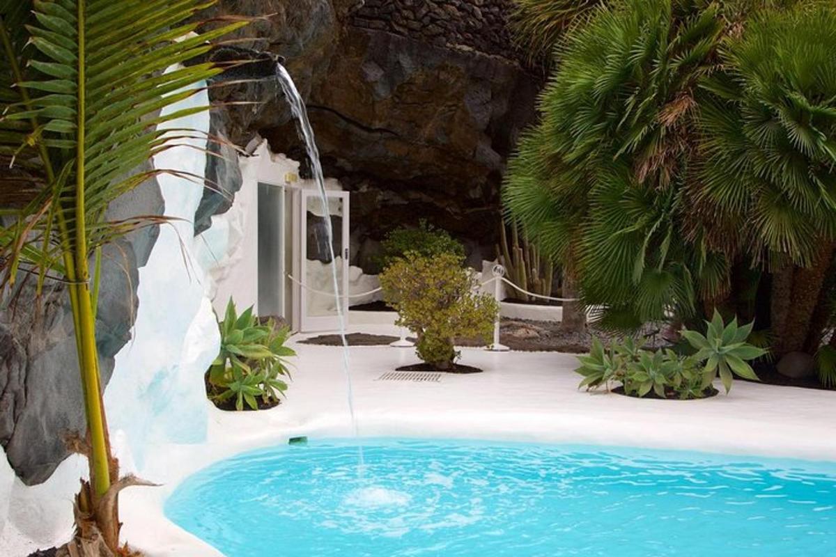 a swimming pool with a water fountain in a garden