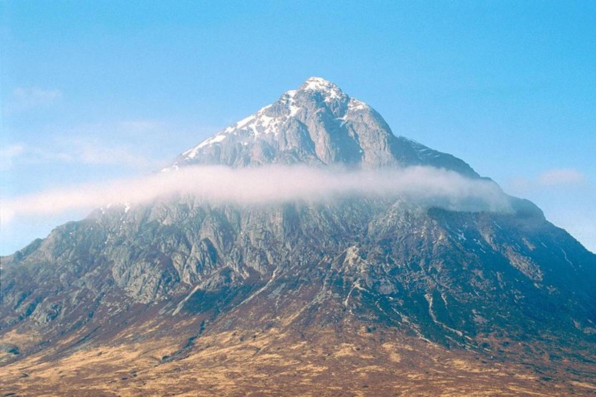 a snow covered mountain with a cloud in front of it