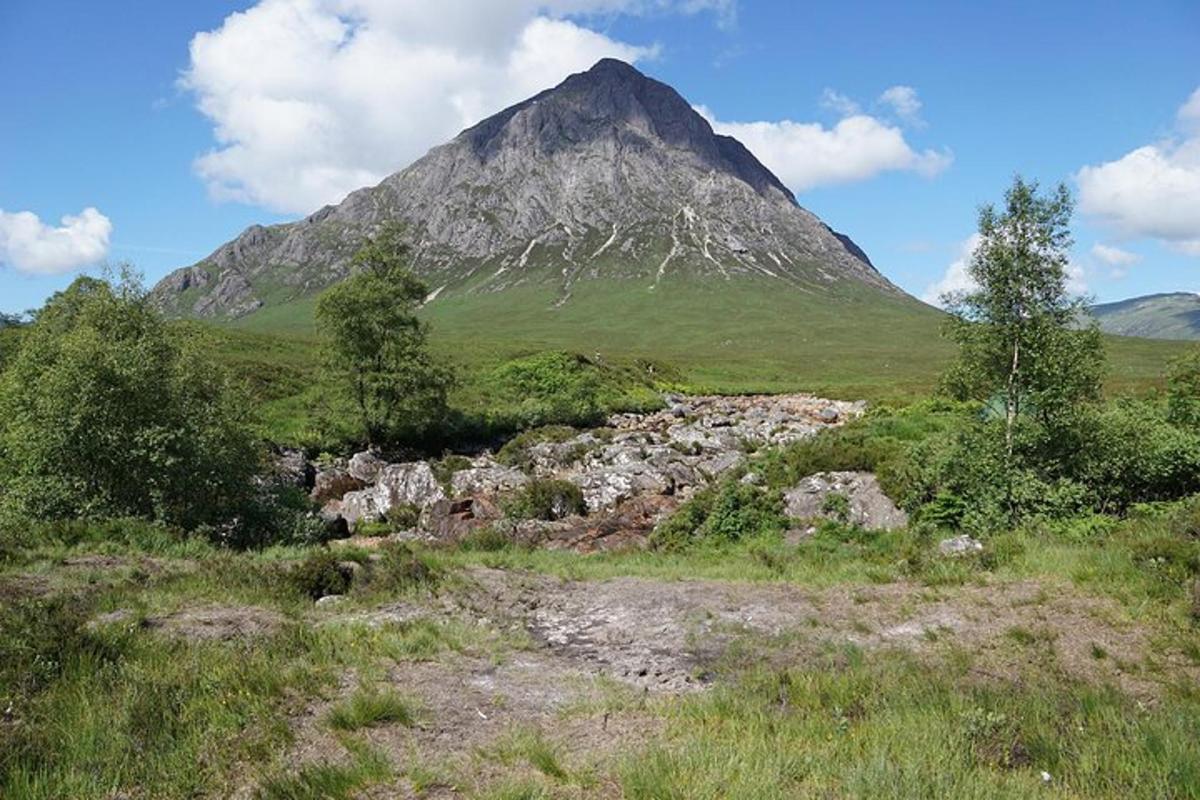 a mountain in the middle of a grassy field