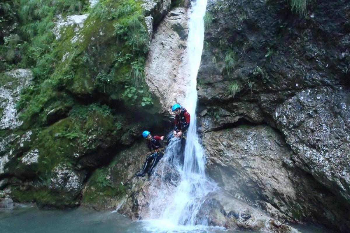 two people are standing in front of a waterfall