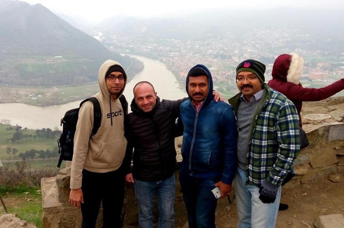 un grup de bărbați care stau pe vârful unui munte