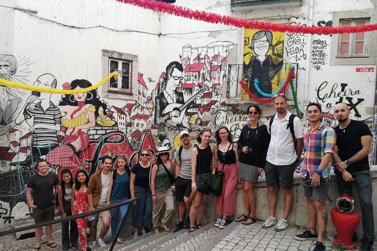 a group of people standing in front of a wall with graffiti