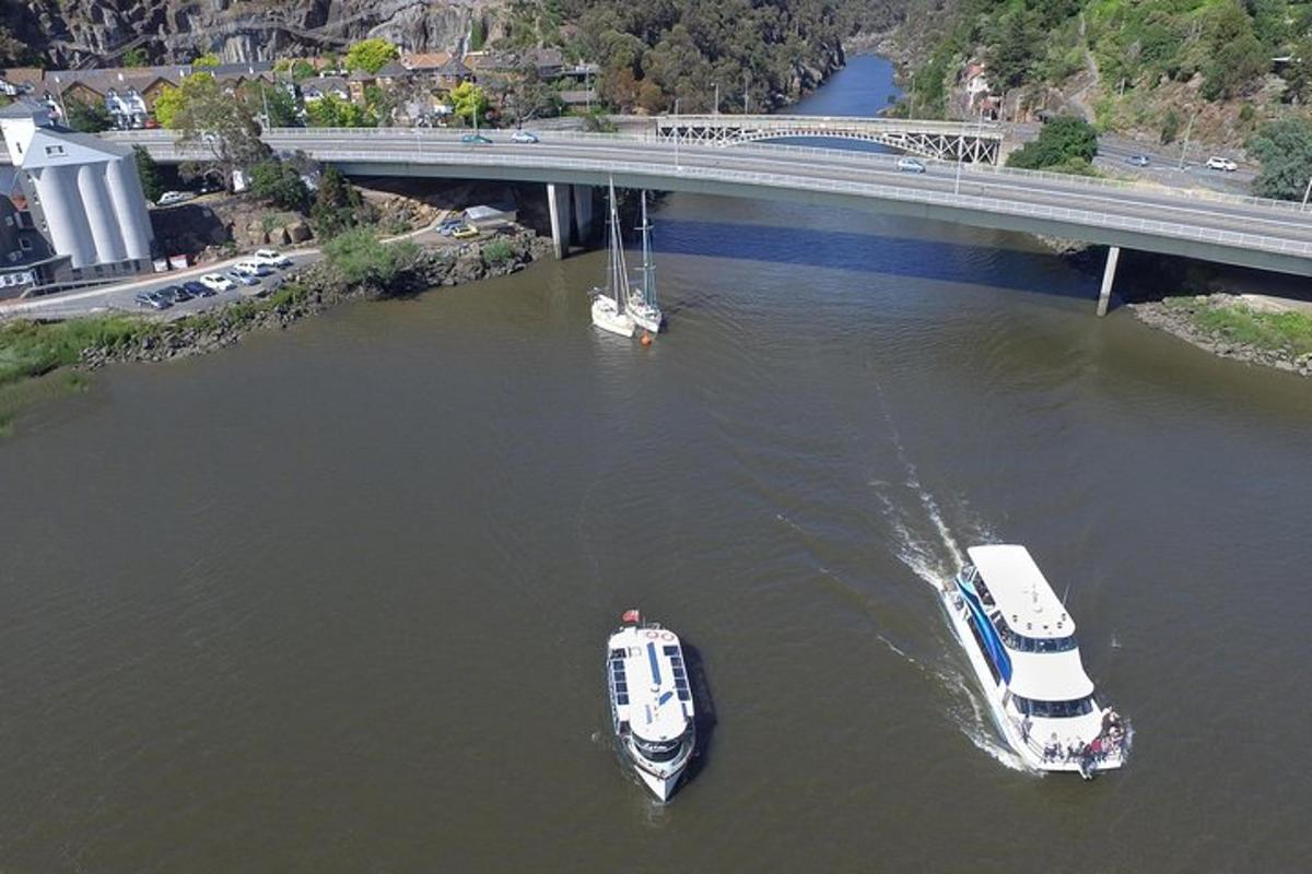 two boats in the water under a bridge