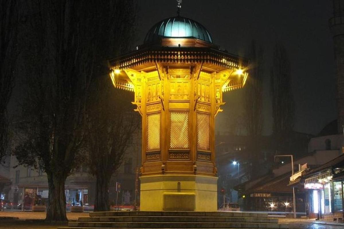 una gran torre groga amb una cúpula a la part superior a la nit