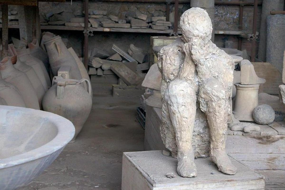 eine Statue einer Person, die neben Vasen steht