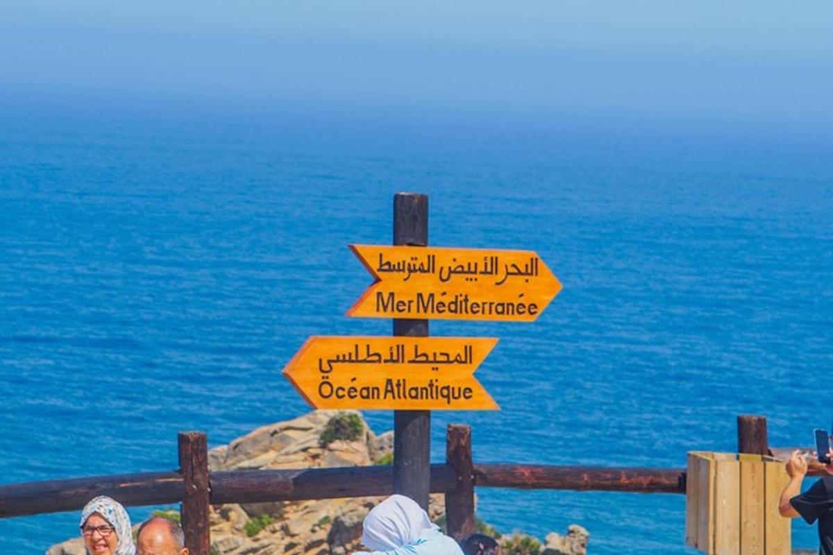 a sign with arrows pointing in different directions near the ocean