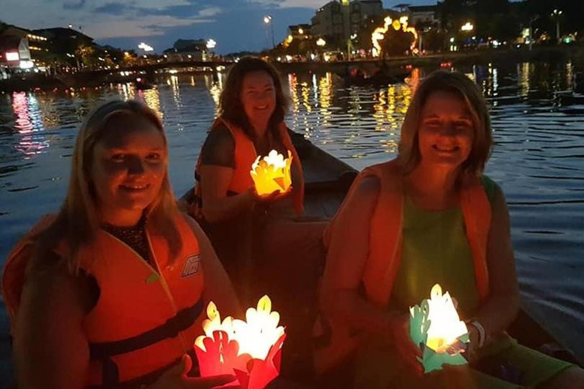 tiga wanita sedang duduk di dalam bot dengan lilin yang menyala
