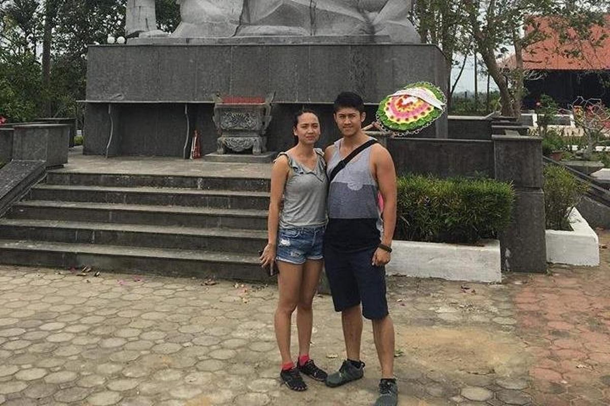 a man and a woman standing in front of a fountain