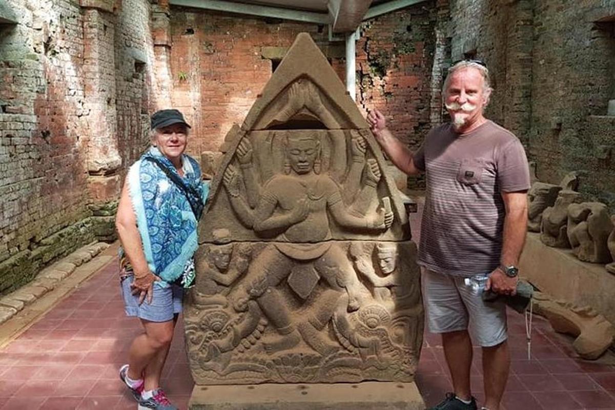 a man and a woman standing next to a stone statue