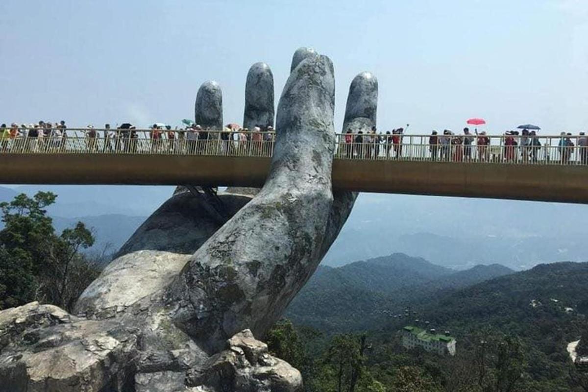 un ponte con una mano gigante che sorregge un ponte sopra una montagna