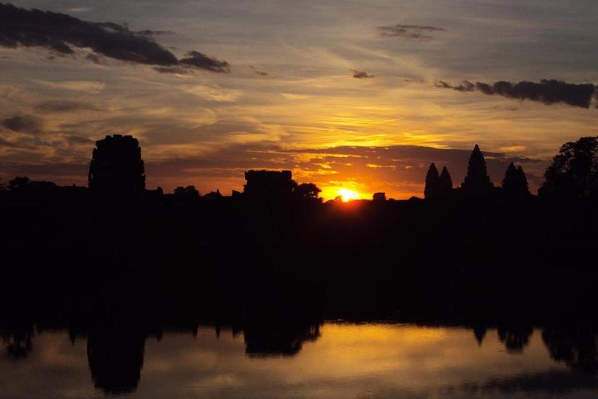 un tramonto su uno specchio d'acqua con il sole che tramonta