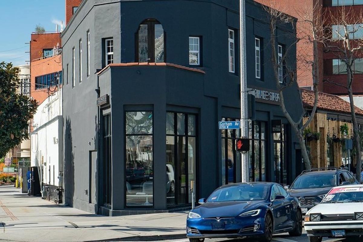 a blue car parked in front of a building on a street