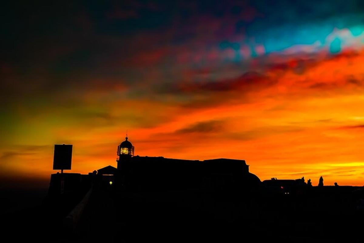 a silhouette of a building with a sunset in the background