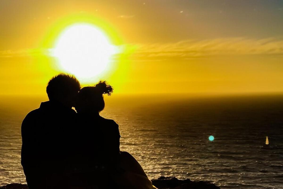 a silhouette of a couple watching the sunset