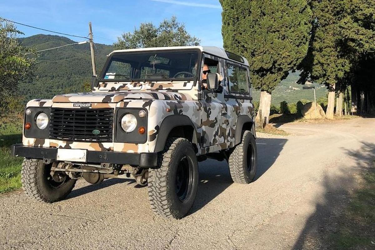ein getarnter Jeep, der auf einer unbefestigten Straße geparkt ist
