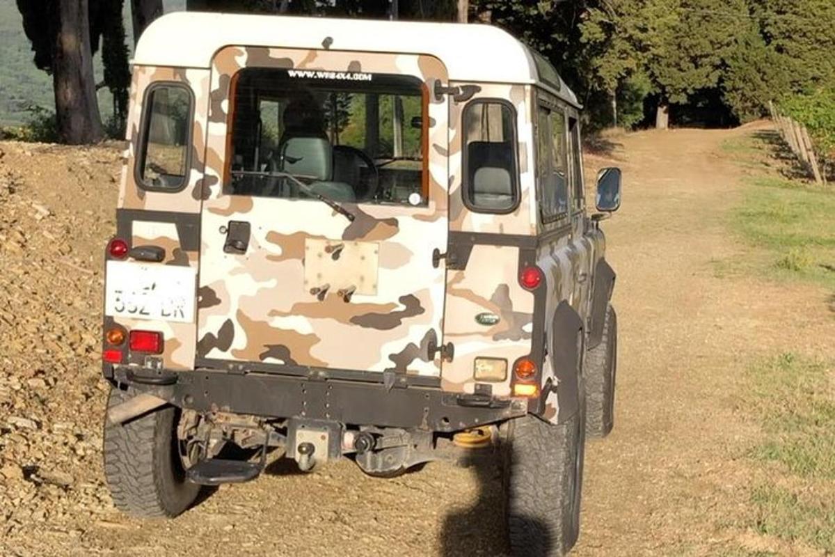 isang camo truck na nakaparada sa maruming kalsada