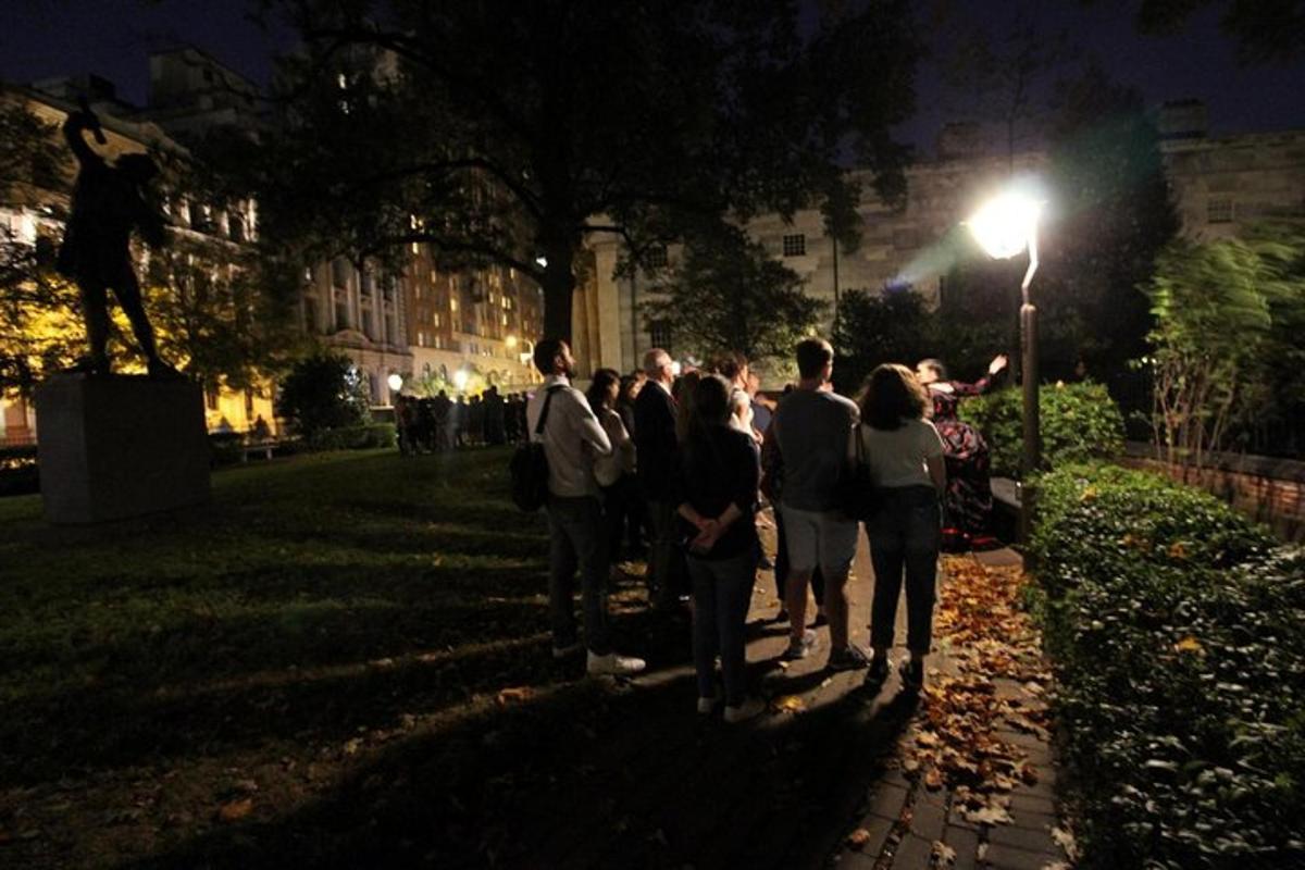 eine Gruppe von Menschen steht nachts in einem Park