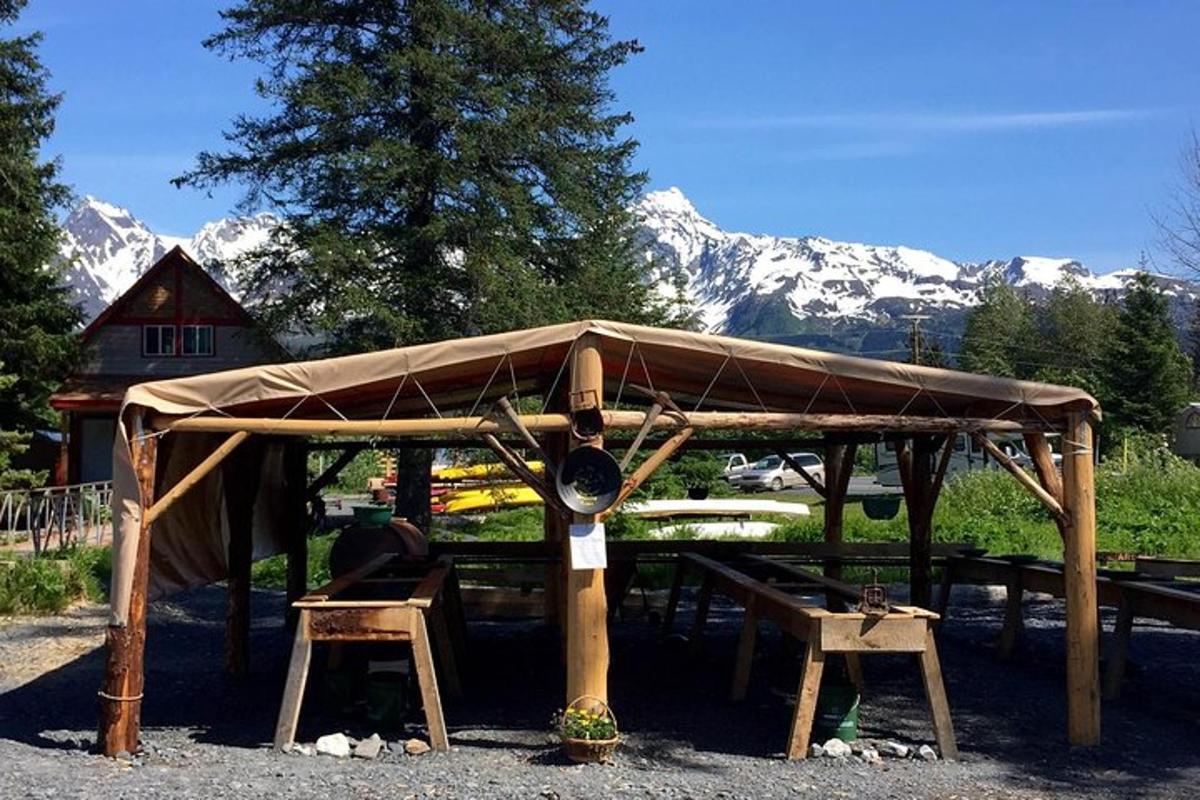 a wooden shelter with mountains in the background