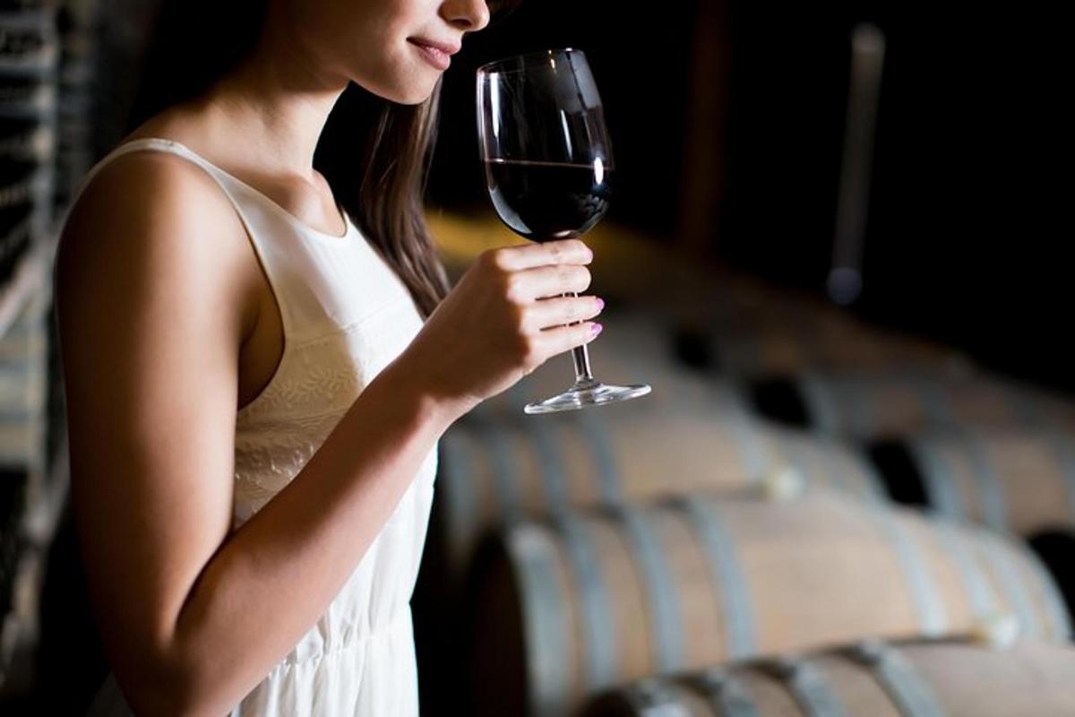 ženska v beli obleki, ki drži kozarec vina