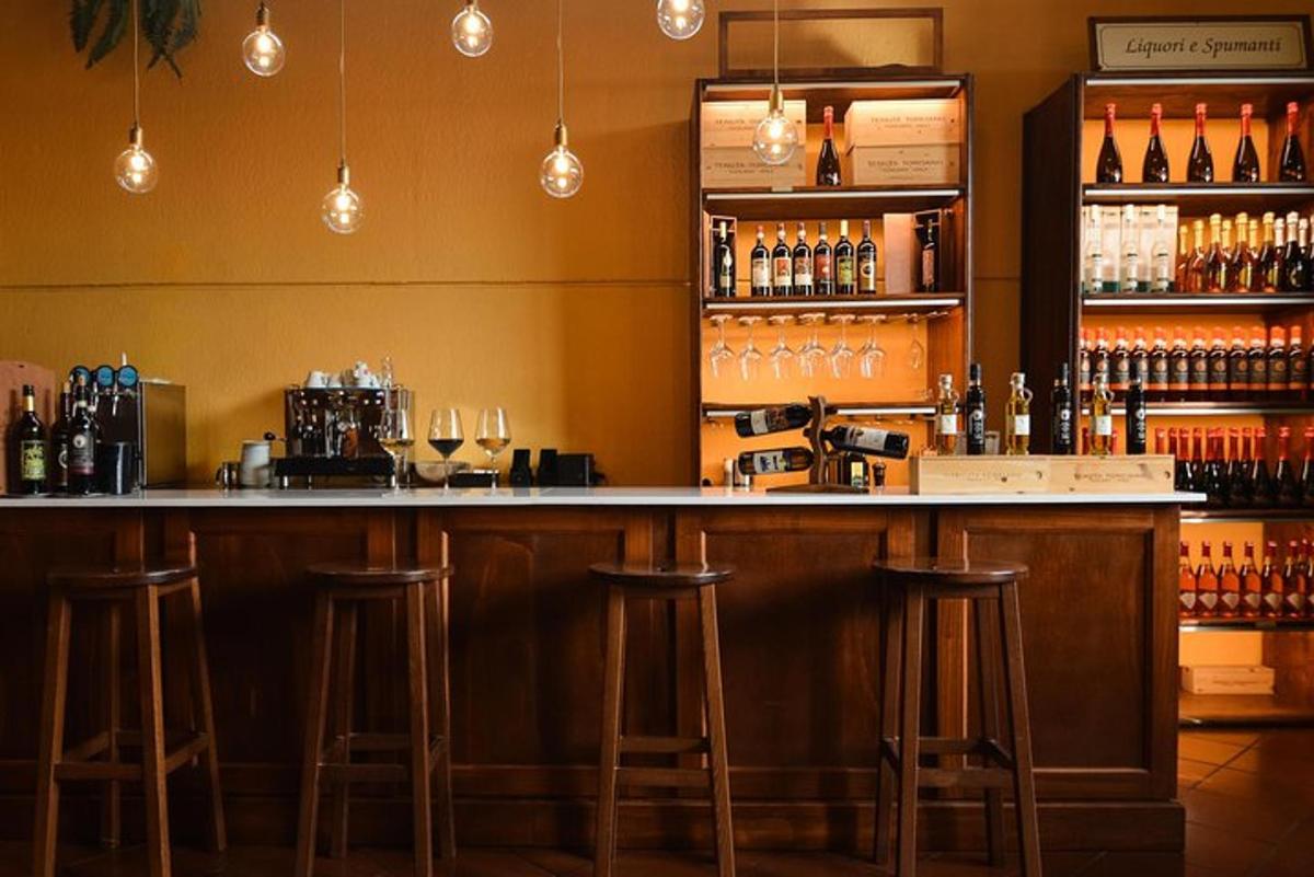 bar z barskimi stoli in steklenicami vina