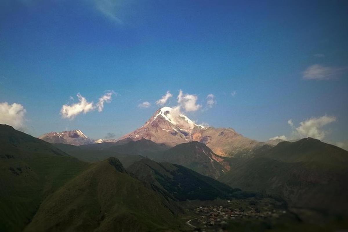 ein schneebedeckter Berg mit einer Stadt davor