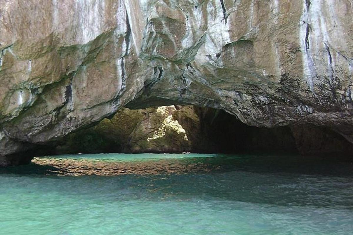 a cave in a rock formation in the water