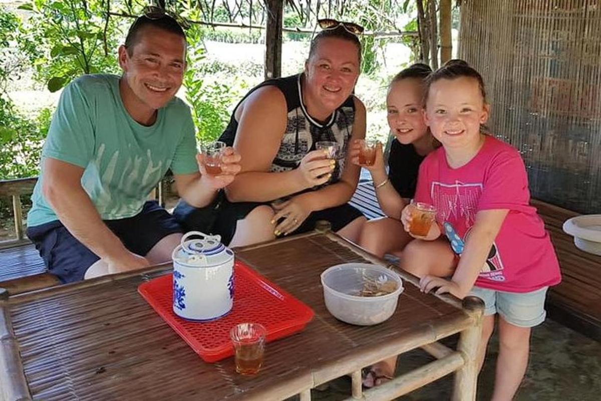 sekumpulan orang duduk di sekeliling meja dengan gelas wain