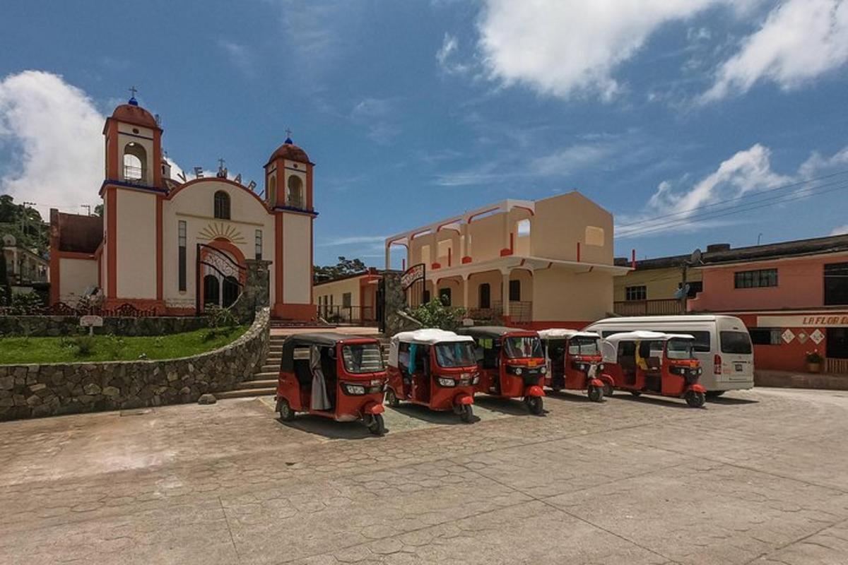 Una fila de vehículos pequeños estacionados frente a una iglesia