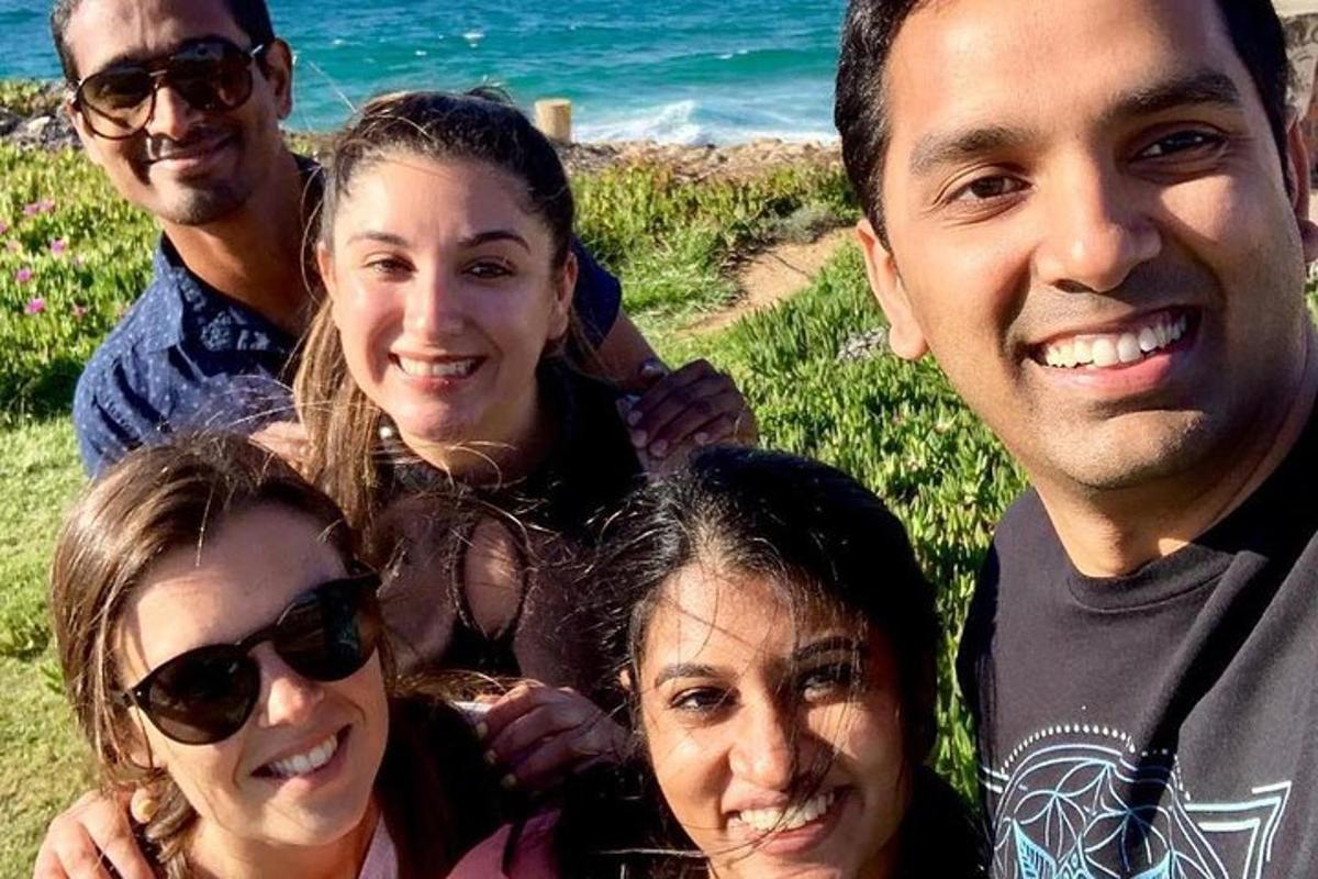 um grupo de pessoas posando para uma foto na praia