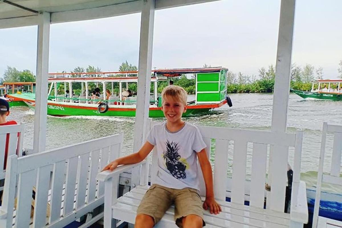ein kleiner Junge sitzt auf einer Bank auf einem Boot
