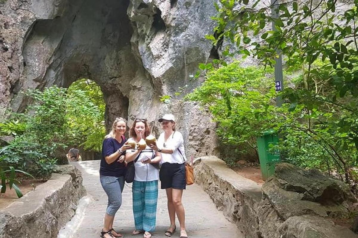 ba người phụ nữ tạo dáng chụp ảnh trước một hang động