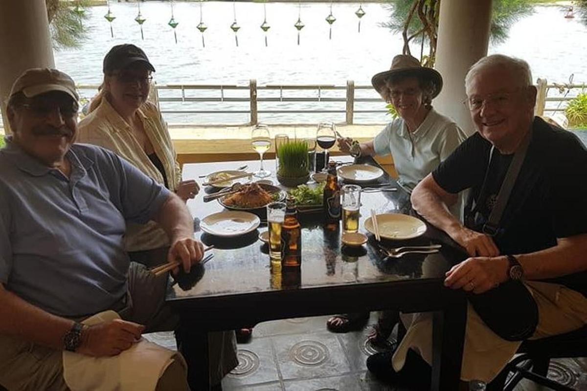 um grupo de pessoas sentadas ao redor de uma mesa com comida