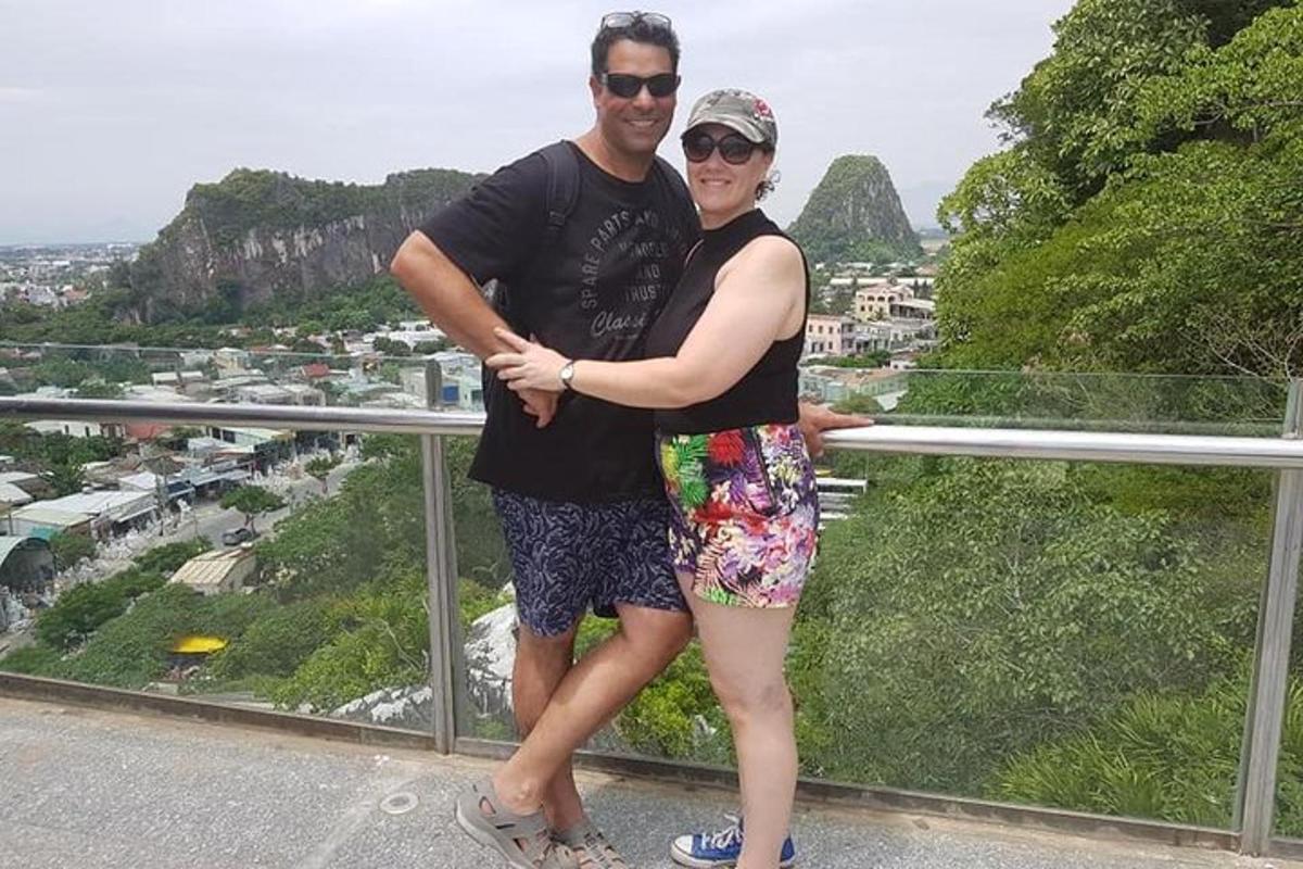 un uomo e una donna in piedi sulla cima di una montagna