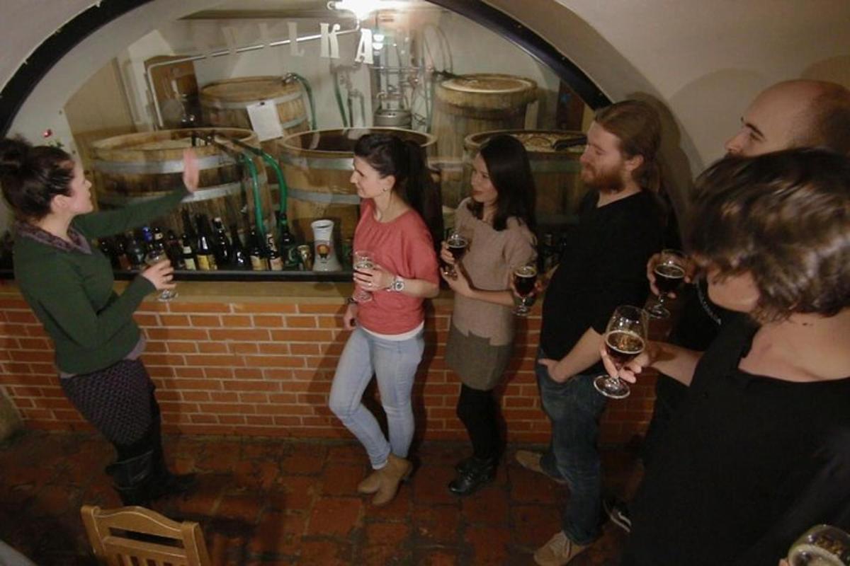 een groep mensen die rond een bar staan met wijnglazen in hun handen