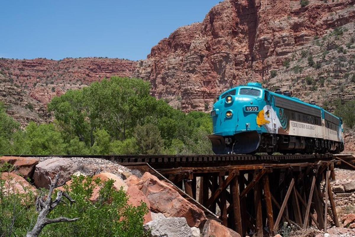 a blue train is crossing a wooden bridge