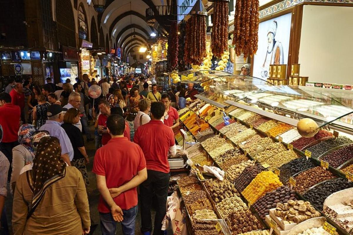 una folla di persone che camminano intorno a un mercato con dolciumi
