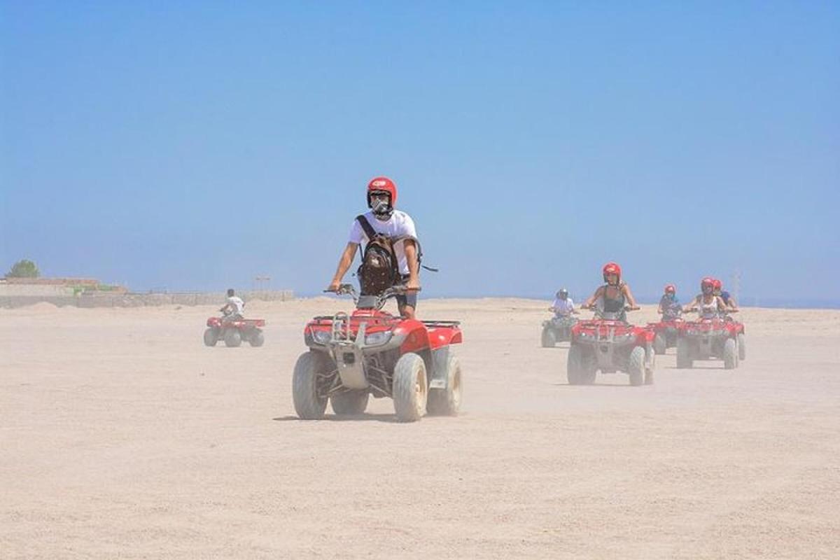 un grup de persones conduint quads al desert