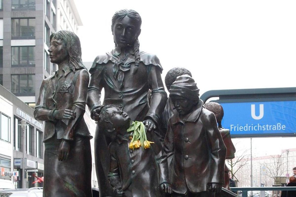en statue av en gruppe mennesker som står ved siden av en buss