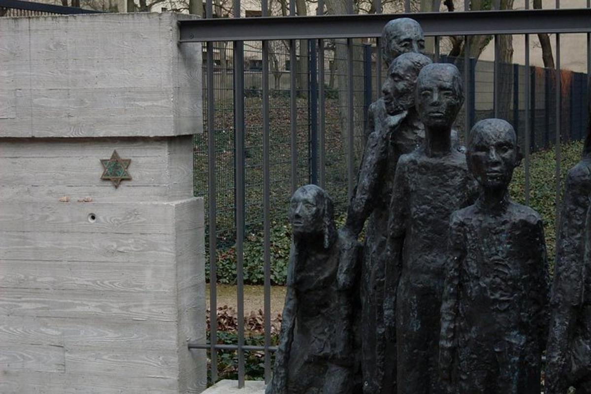 en statue av en gruppe mennesker ved siden av et gjerde