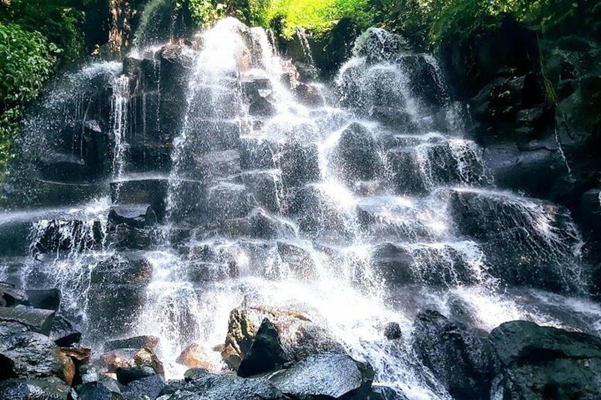 a waterfall on the side of a mountain with rocks