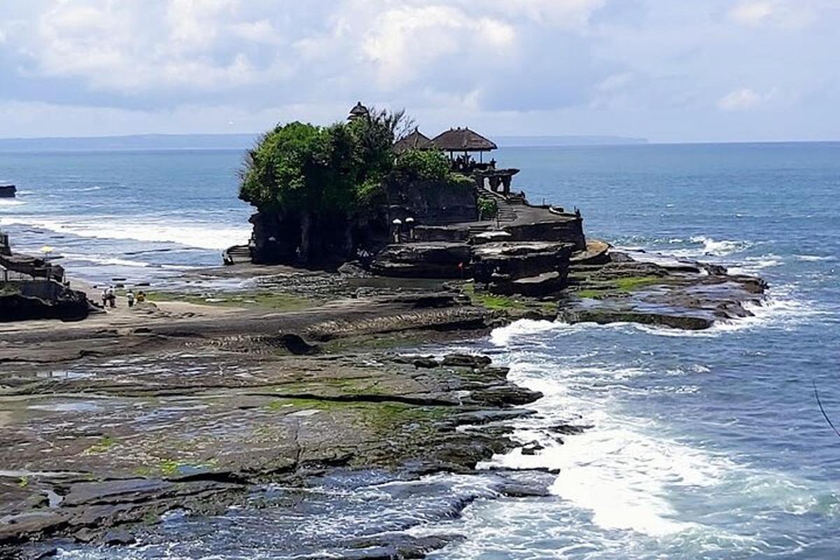 un gruppo di persone in piedi su un'isola rocciosa nell'oceano