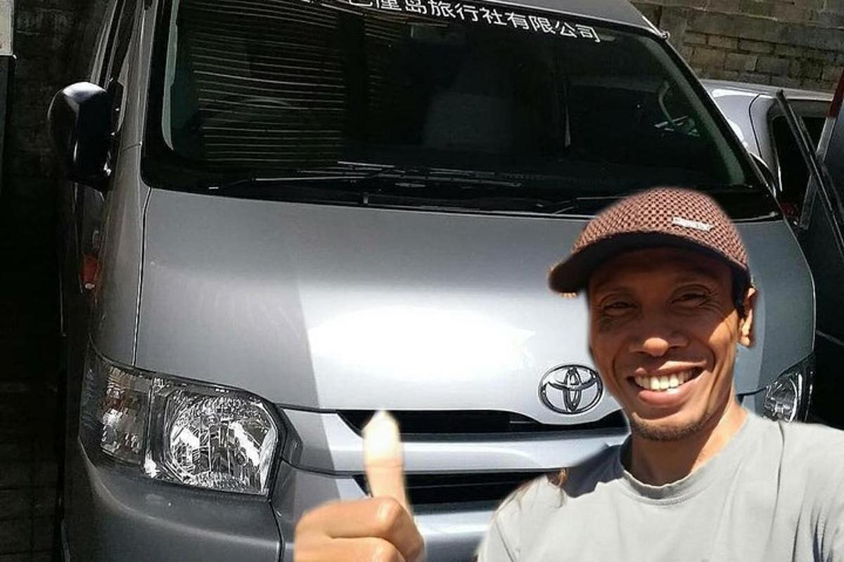 un home fent un gest d'aprovació amb el polze davant d'una furgoneta