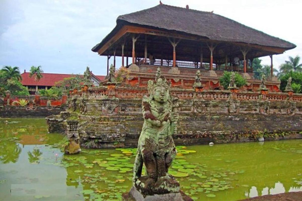 una estàtua d'un drac en un estany davant d'un edifici