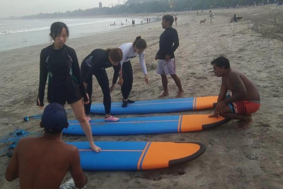 a group of people working on surfboards on the beach