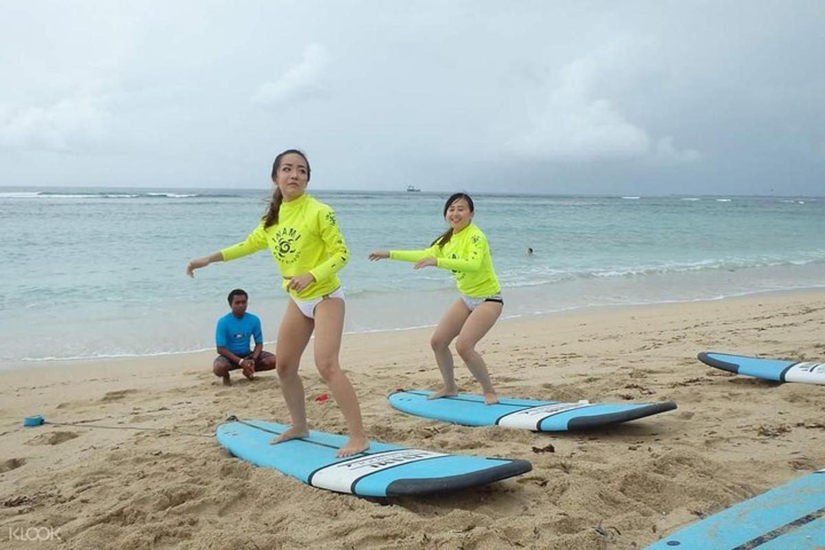 two girls are standing on surfboards on the beach