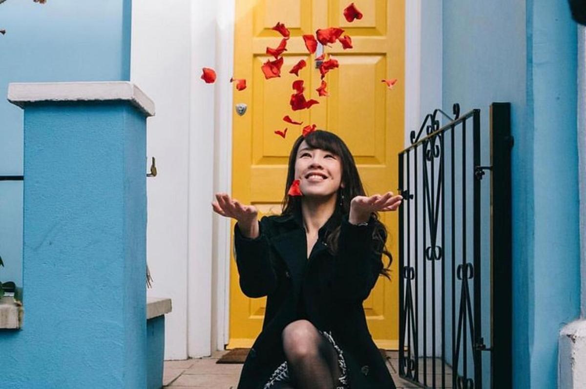 a woman sitting in front of a door with red butterflies